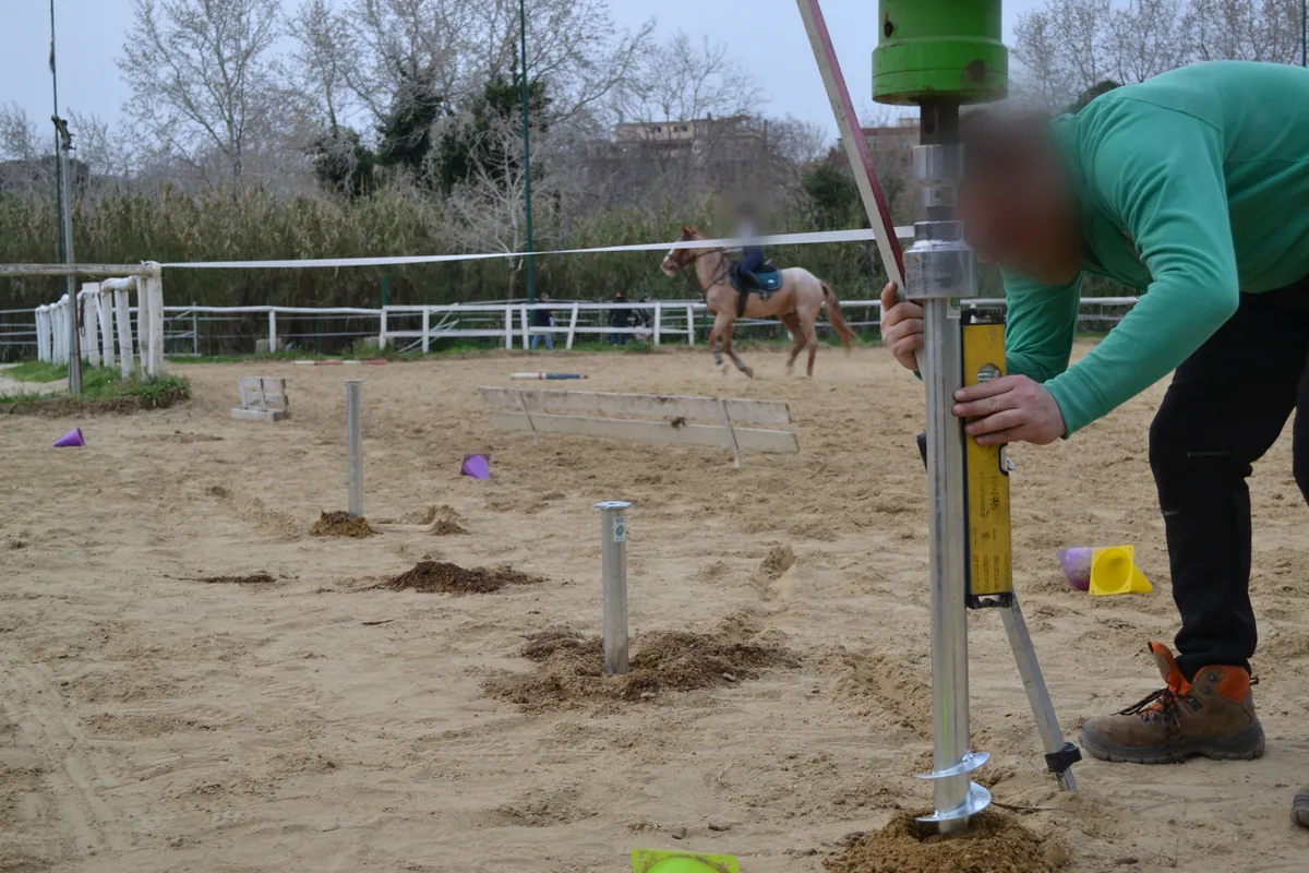 Operatore che appoggia la livella digitale al fusto del T-Block ancora agganciato alla testa rotativa.