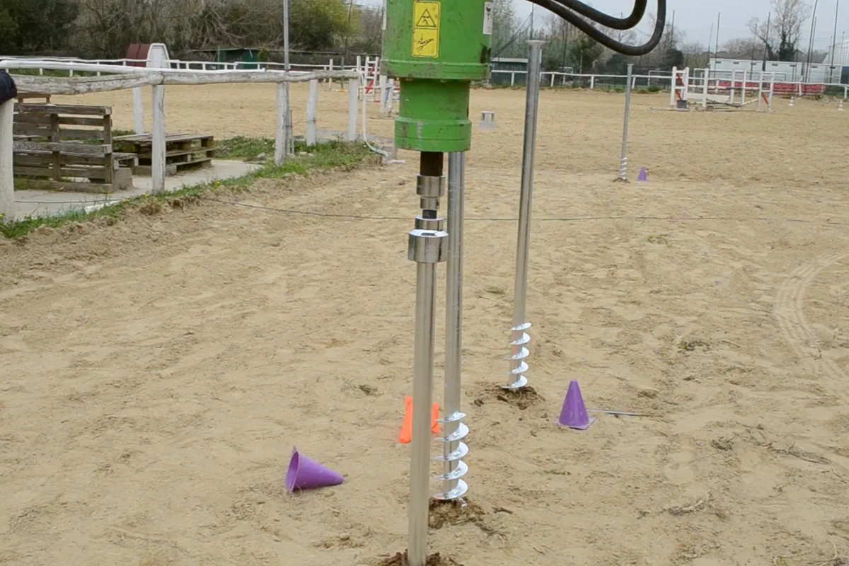Il T-Block che entra nella sabbia del maneggio sotto la testa rotativa, con le spire ancora visibili.