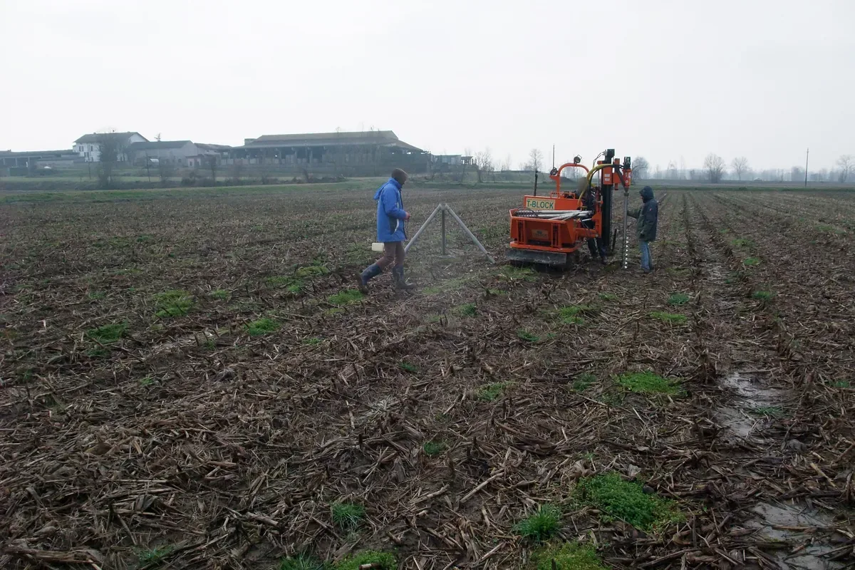 Treppiede di prova sopra un T-Block nel campo, con la macchina cingolata e la squadra poco lontano.