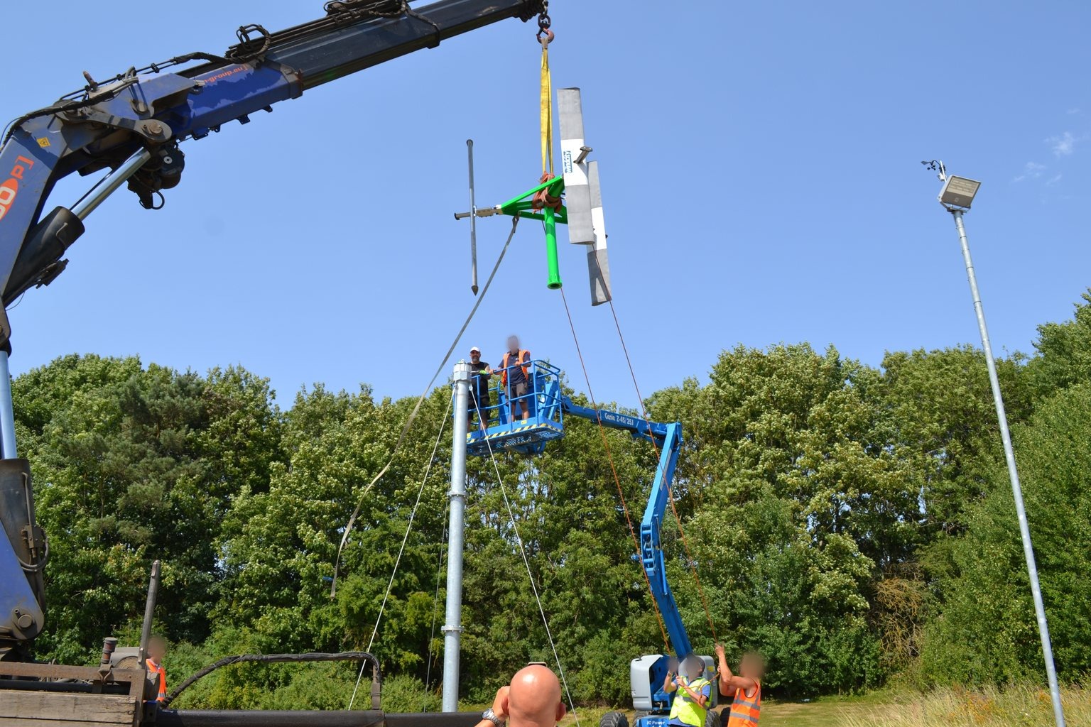 Micro turbina eolica a geometria variabile realizzata da Windcity durante il montaggio su palo struttura portante ancorata al terreno con fondazioni a vite T-Block.