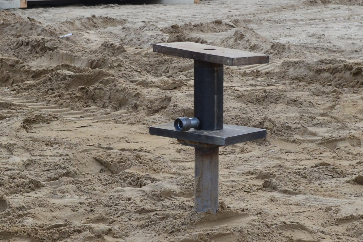 T-Block di prova avvitato nella sabbia della spiaggia di Rimini, con il martinetto idraulico appoggiato sulla testa.