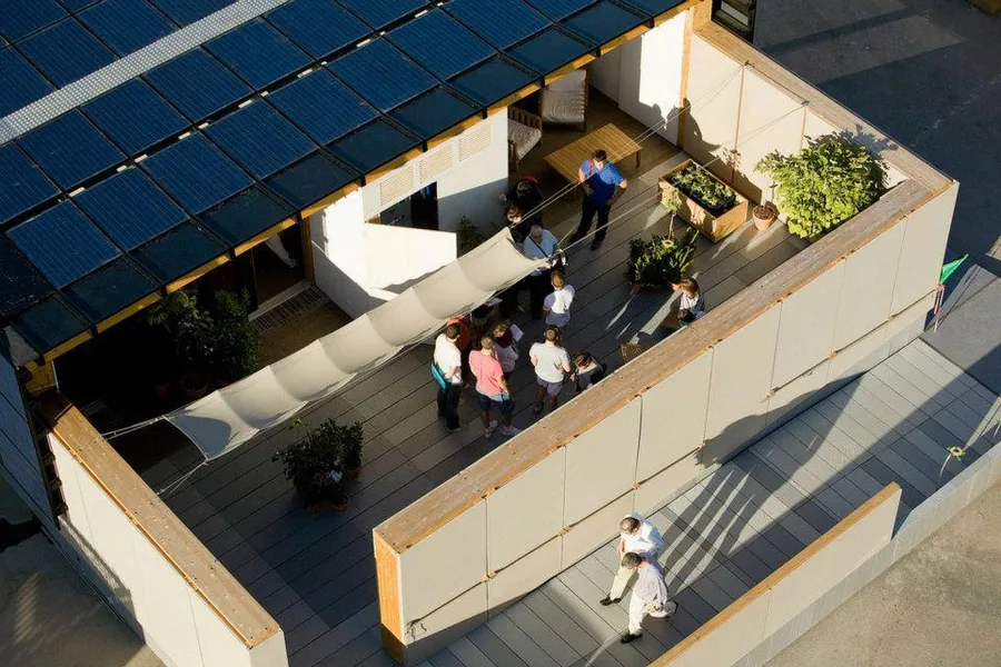 Il prototipo MED IN ITALY visto dall'alto al Solar Decathlon Europe di Madrid: copertura fotovoltaica, terrazza in legno, vele e orto.