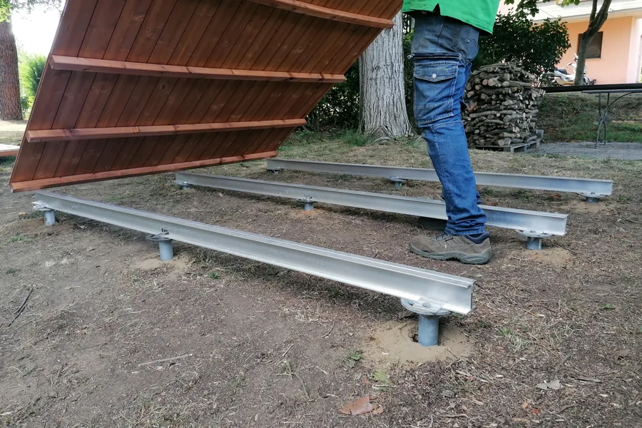 La base di appoggio in legno di una casetta da giardino che viene fissata sul telaio ancorato alle fondazioni a vite T-Block.