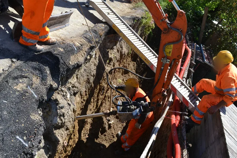 Consolidamento di una strada bellissima a San Gimignano: la testa rotativa dell'escavatore avvita quasi in orizzontale un ancoraggio T-Block nella parete della strada. Un intervento difficile reso facile.