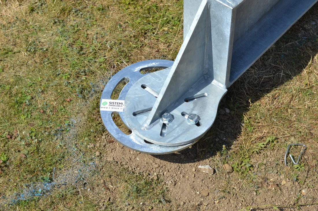 Flangia rotonda di un T-Block a filo terra, con il montante in acciaio zincato fissato tramite bulloni