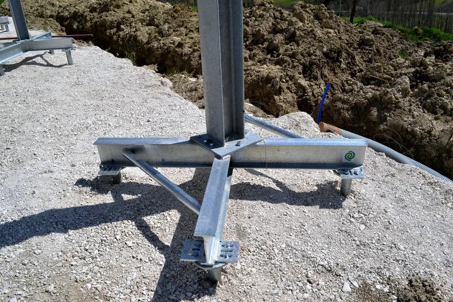 Crociera in acciaio zincato sotto una colonna, imbullonata sulle flange di più T-Block avvitati nel ghiaino.