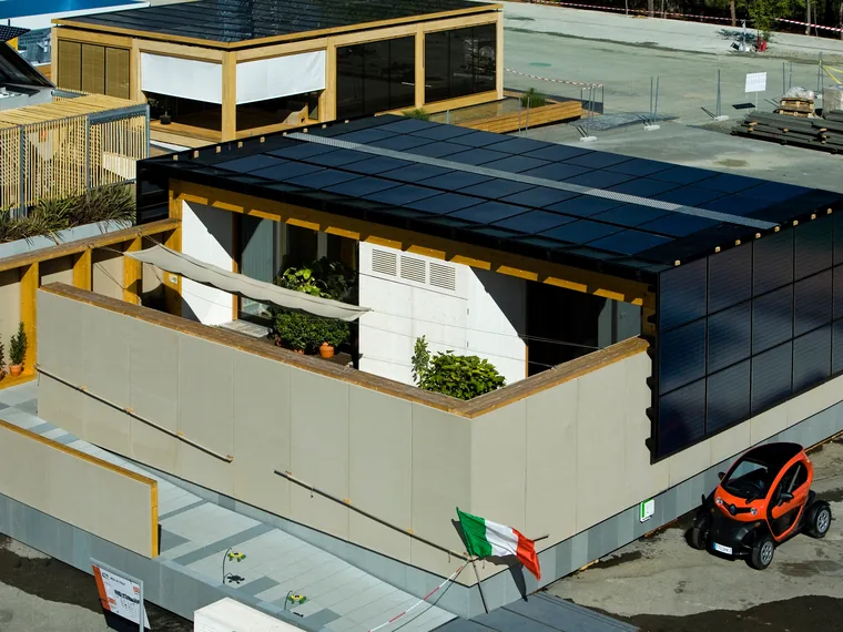 Il prototipo di abitazione MED IN ITALY al Solar Decathlon Europe, con facciata fotovoltaica e bandiera italiana.