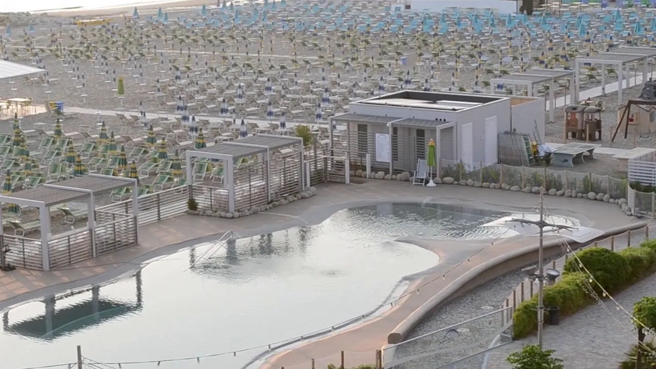 Lo stabilimento Spiagge Luna visto dall'alto: la piscina, le pergole bianche e le file di ombrelloni sulla spiaggia.