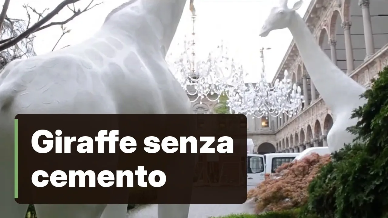 Due Giraffe in Love bianche di Qeeboo nel cortile di un palazzo storico, con un lampadario di cristallo.