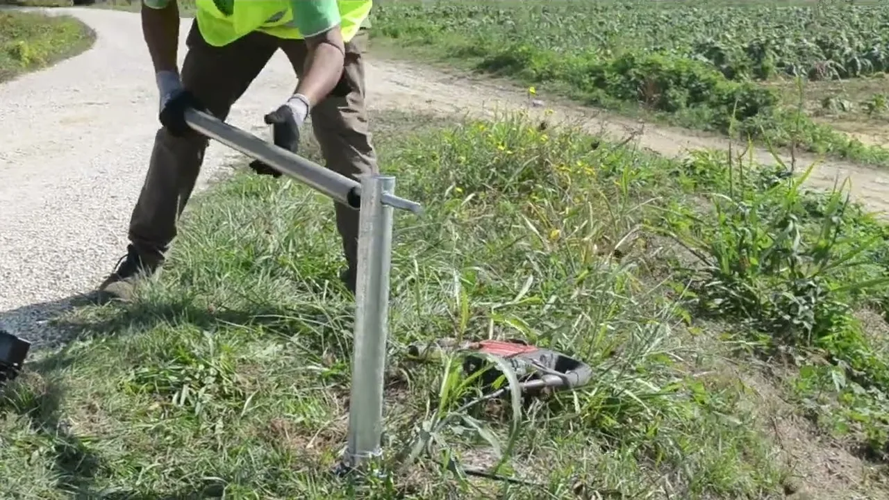 Operatore che gira il manico a T su un T-Block senza testa a bordo di una strada bianca.